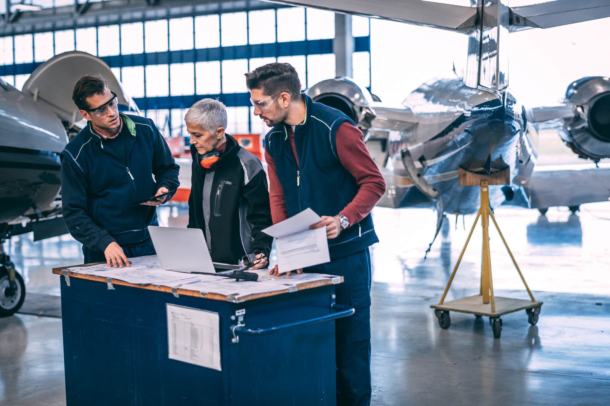 Maintenance team reviewing inspection paperwork in hangar